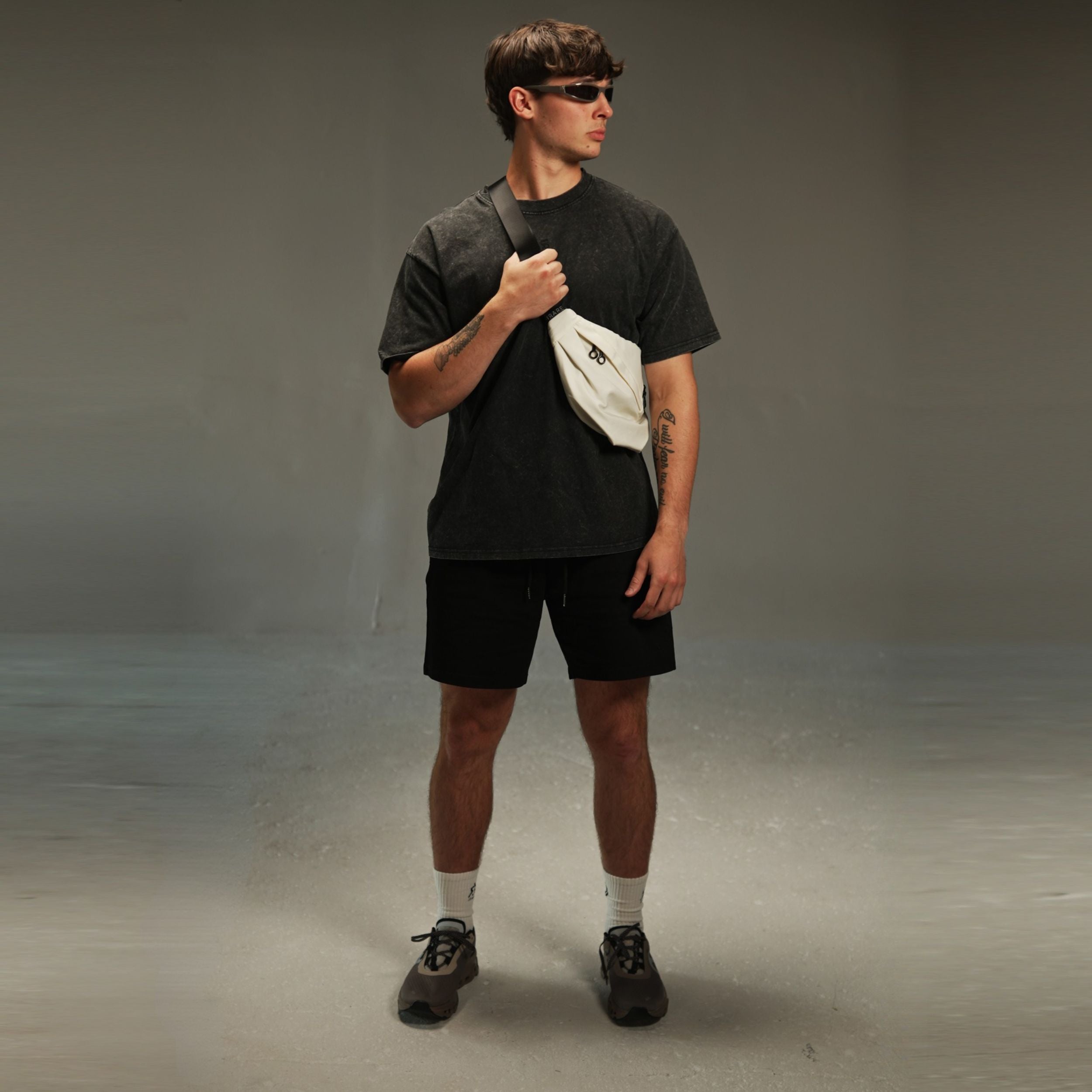 men’s acid-washed t-shirt in washed black, styled look with crossbody bag
