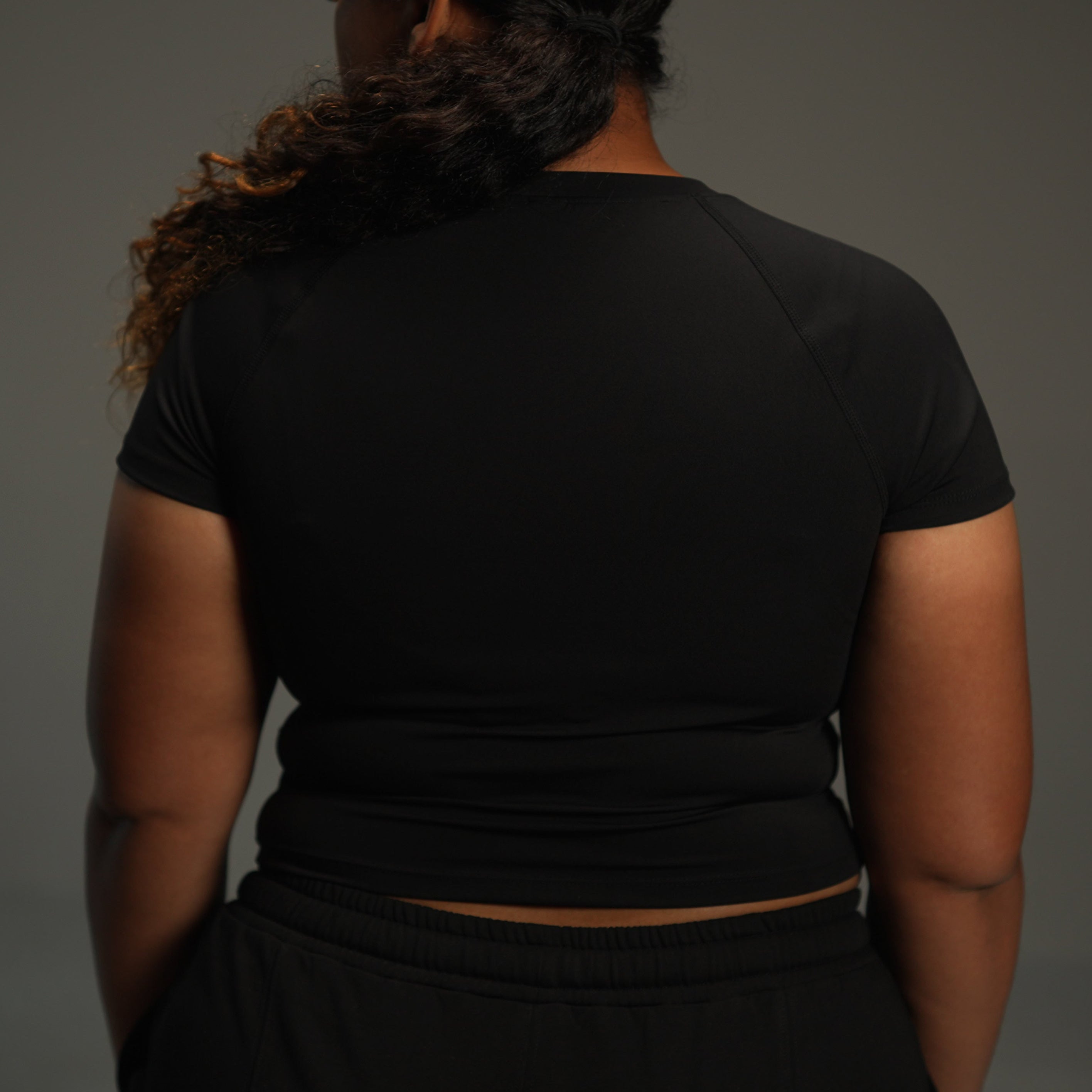 short-sleeve raglan top in black, back view close-up