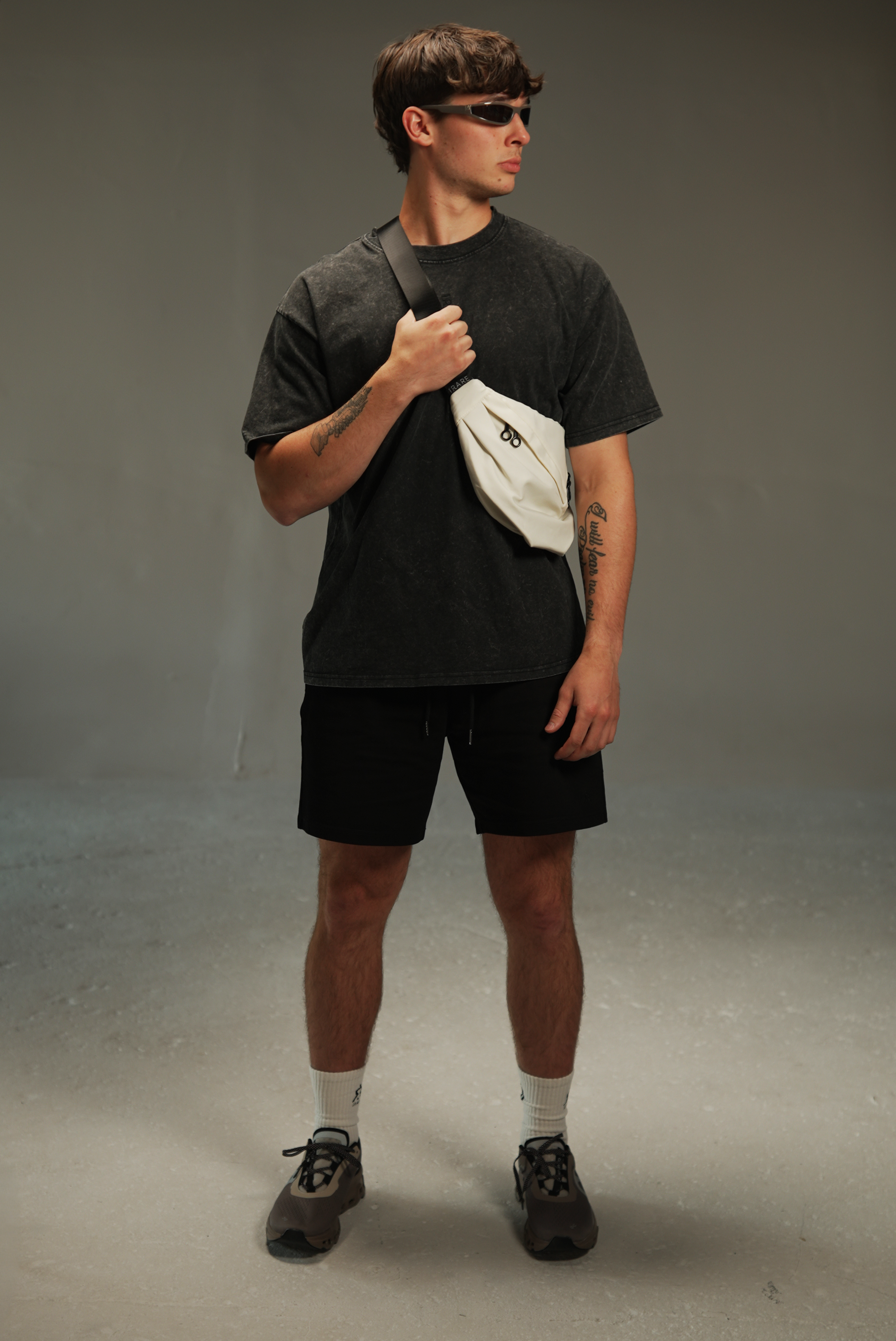 men’s acid-washed t-shirt in washed black, styled look with crossbody bag