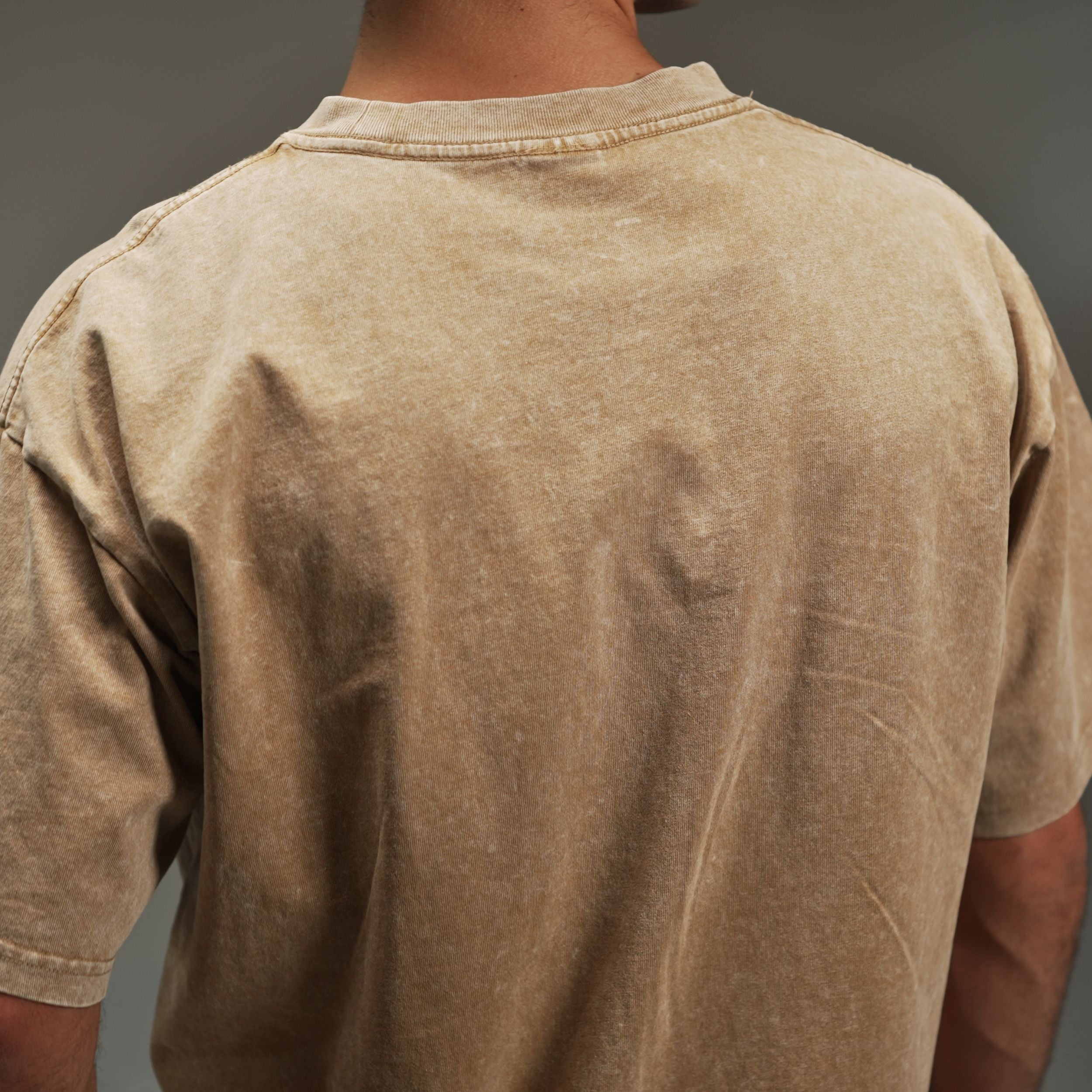 men’s acid-washed t-shirt in washed sand, back close-up view