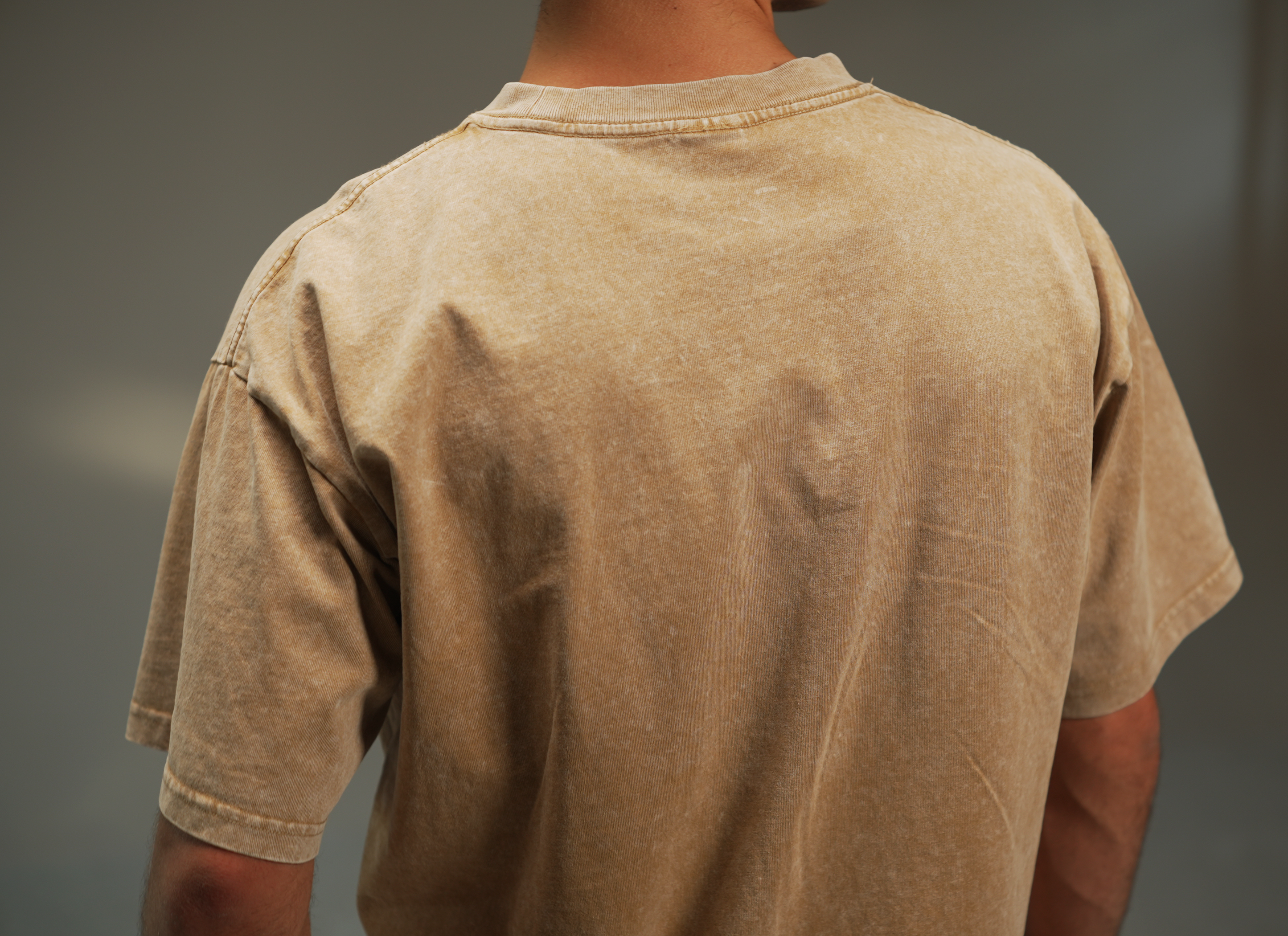 men’s acid-washed t-shirt in washed sand, back close-up view
