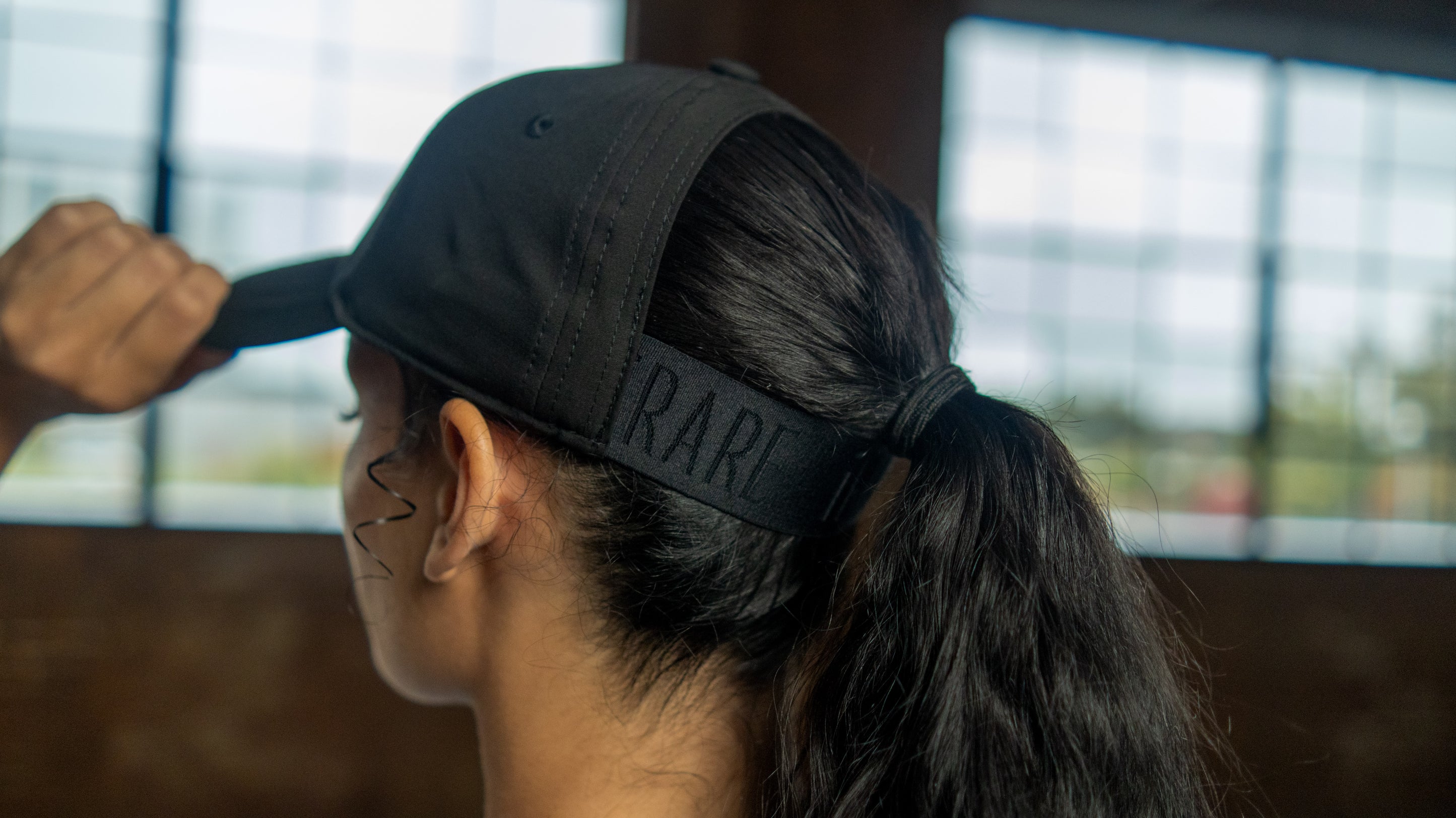 Close-up of ponytail cap back opening and logo strap