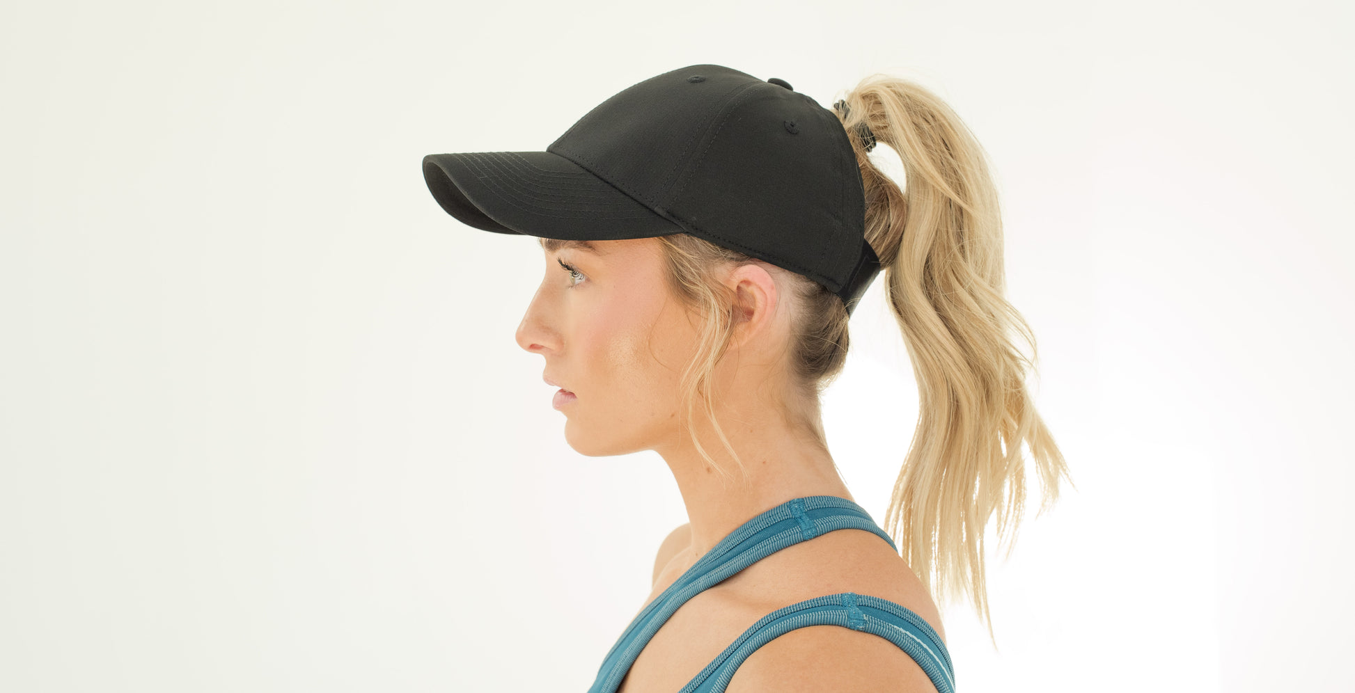 Blonde model in black ponytail cap side profile